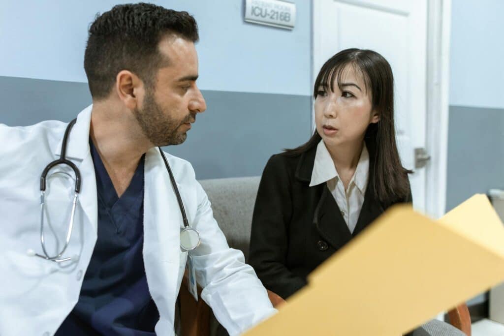 A doctor consults with a colleague in a hospital, examining medical documents.