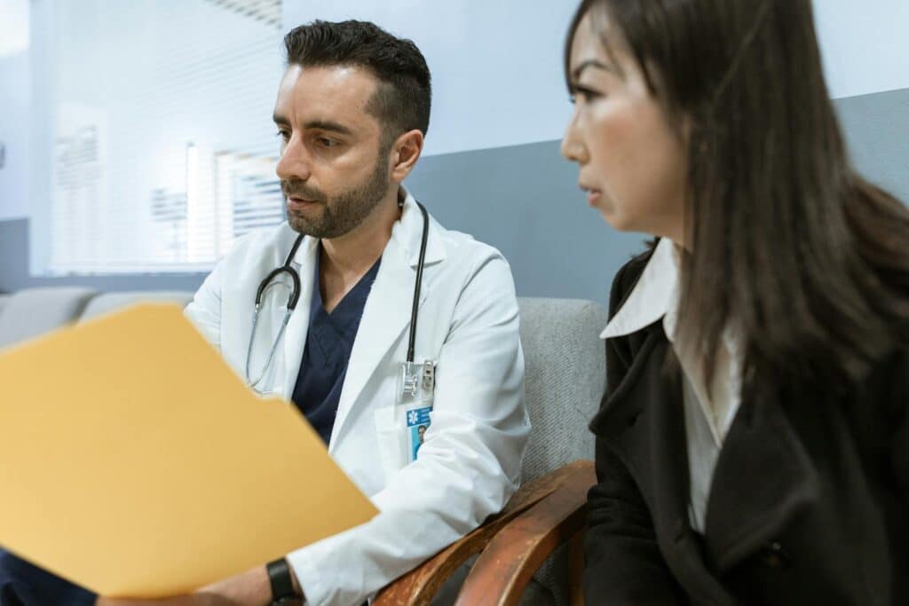 Doctor discusses health records with a patient in a clinical setting.