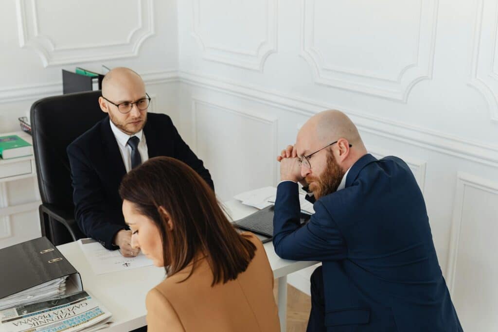 Three business professionals engaged in a meeting in a stylish office setting.